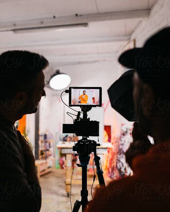 Production crew looking at playback on a monitor while filming a scene.